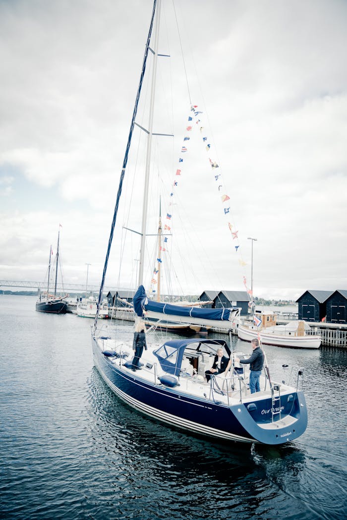 Luxury yacht adorned with nautical flags docking at a serene marina on a sunny day.